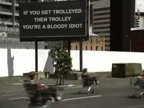 Trolley riders speed past sign in Progressive Enterprises TV ad