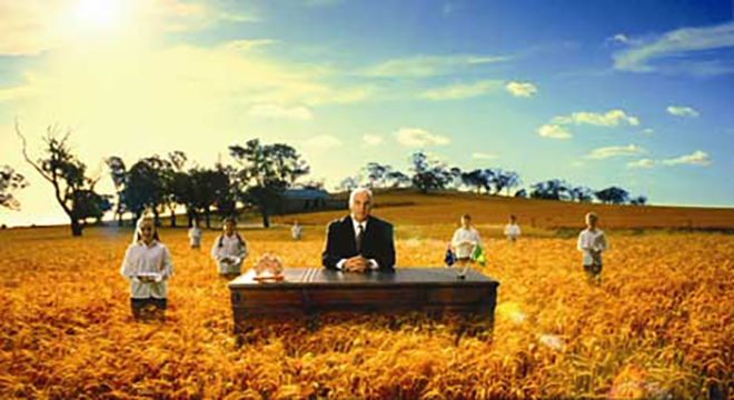 Sam Kekovich by a wheat field with choir boys and girls